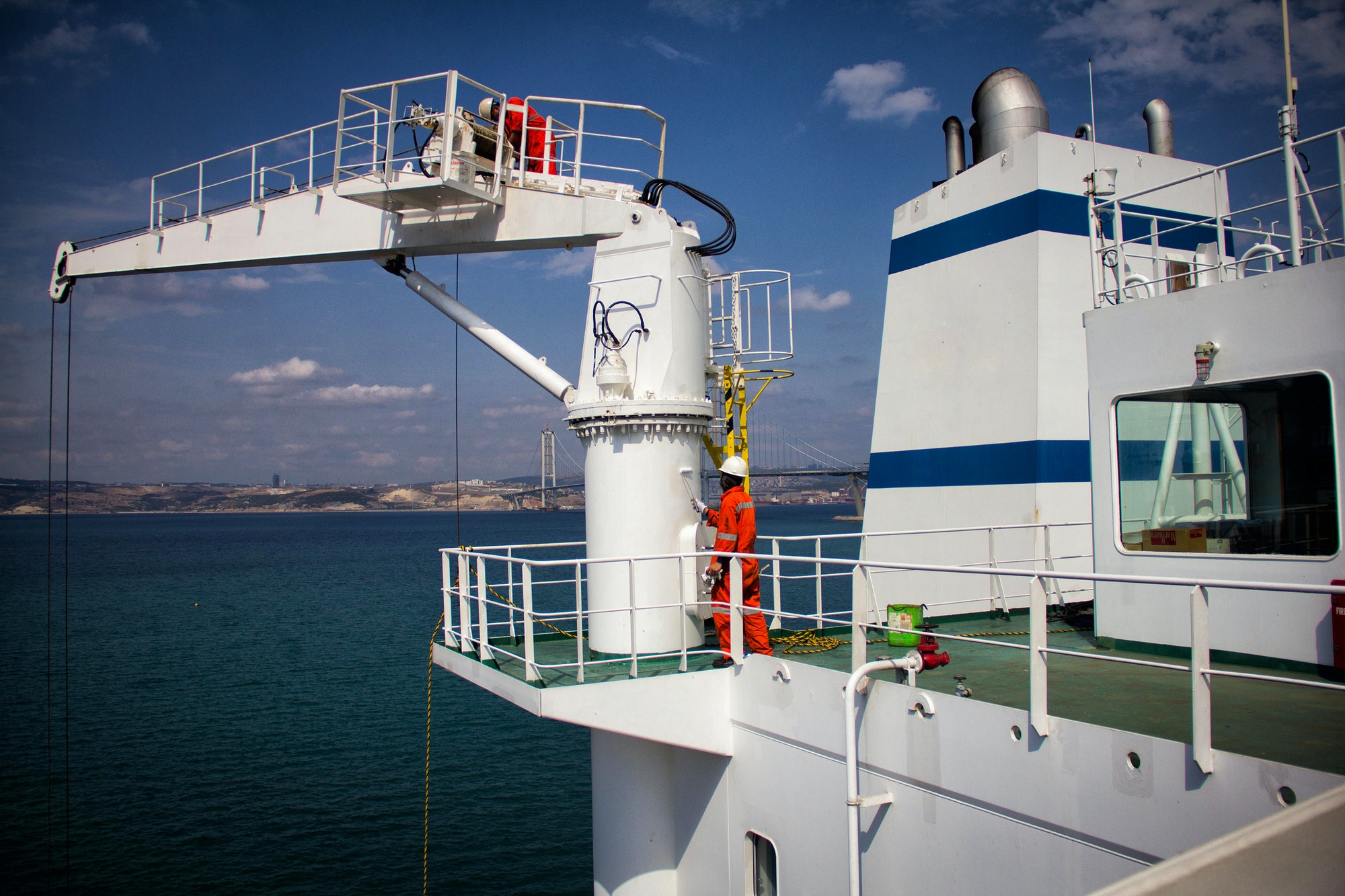 A large tanker cargo ship is being renovated and painted in shipyard dry dock